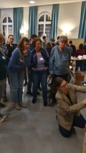 Gemeinsame Arbeit an den Walking Flipcharts. Eine Frau schildert ihre Idee, eine zweite schreibt sie auf eine große Flipchart.